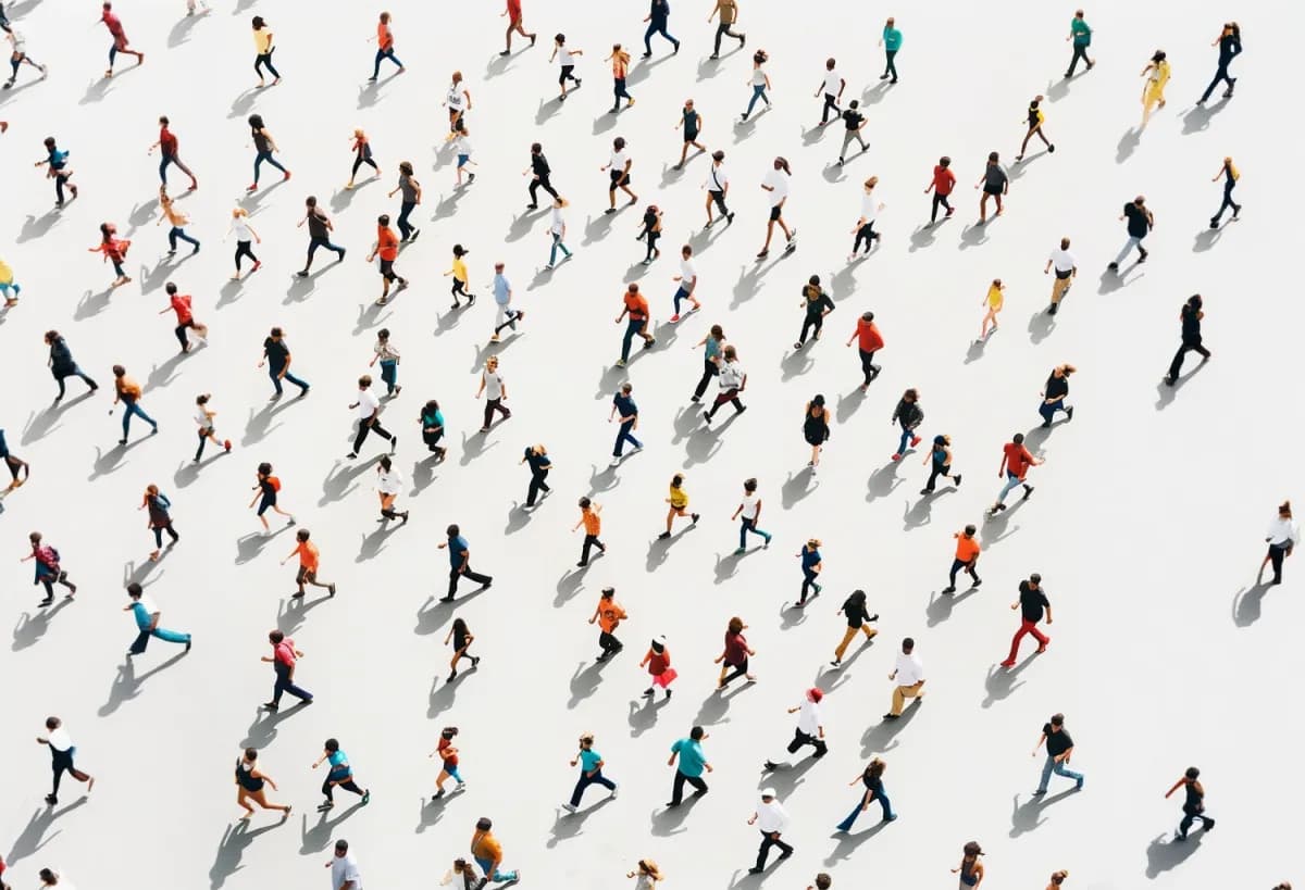 A diverse crowd moving in different directions, viewed from above.