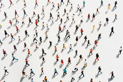 A diverse crowd moving in different directions, viewed from above.